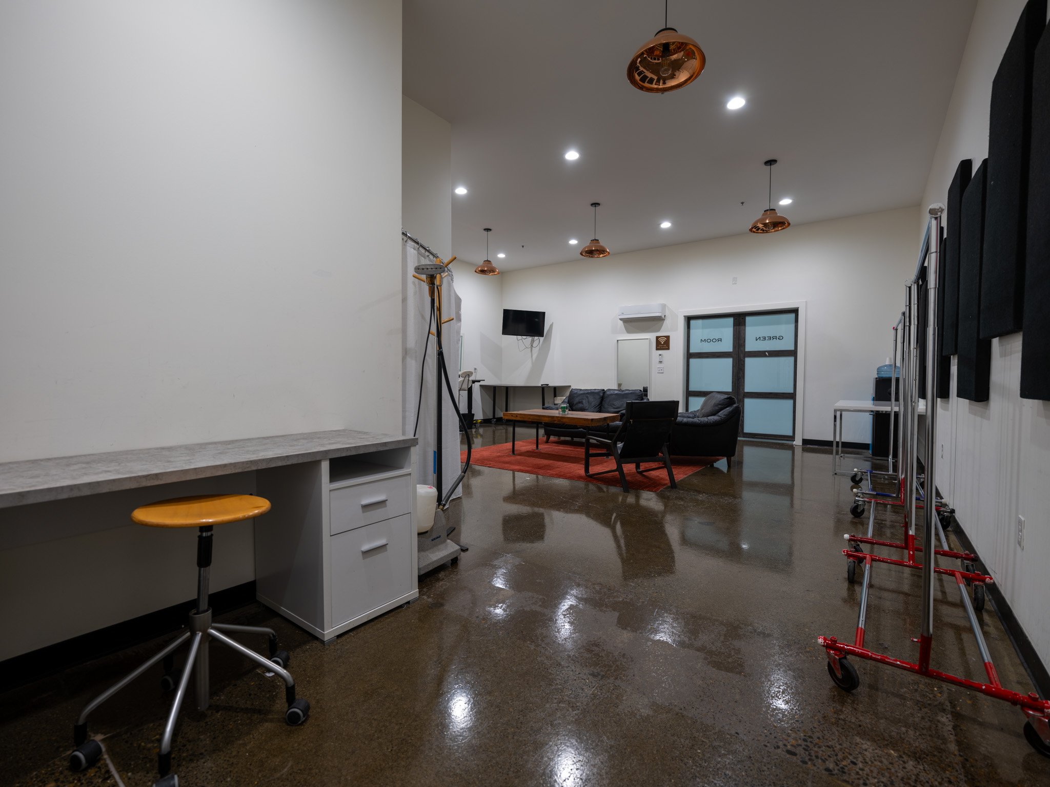 Hair/Makeup/Green Room with 2 styling stations, private full bathroom with shower, casual seating arrangement and plenty of space for wardrobe racks