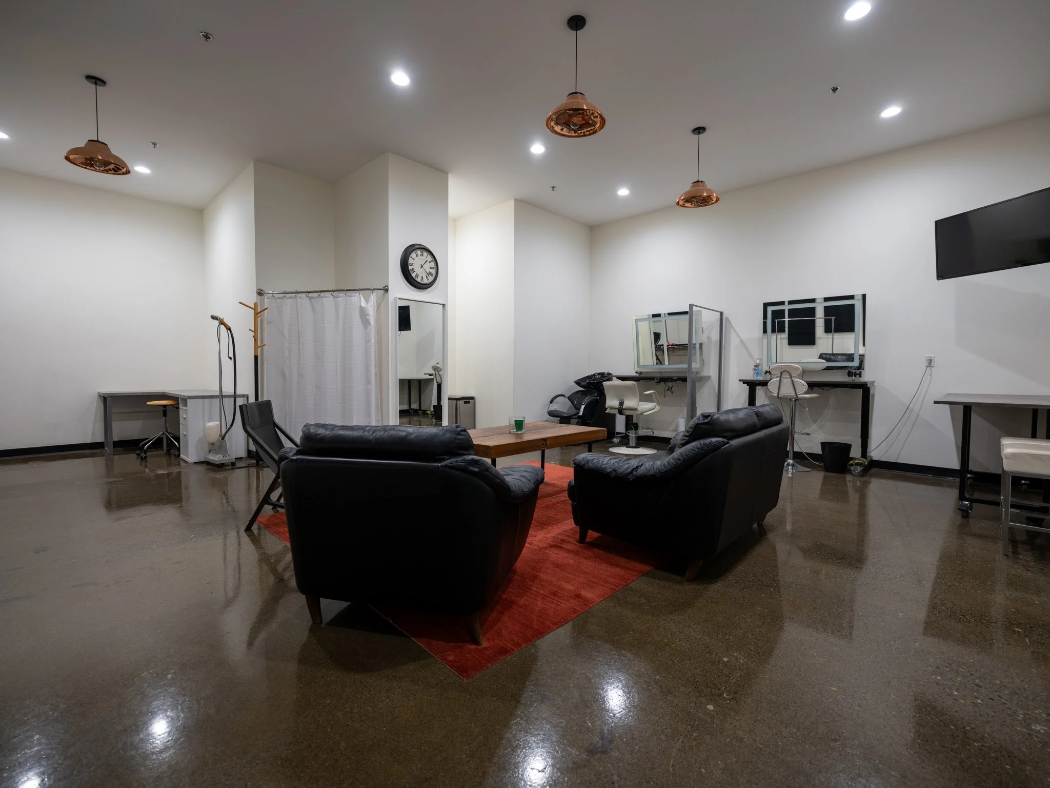 Hair/Makeup/Green Room with 2 styling stations, private full bathroom with shower, casual seating arrangement and plenty of space for wardrobe racks