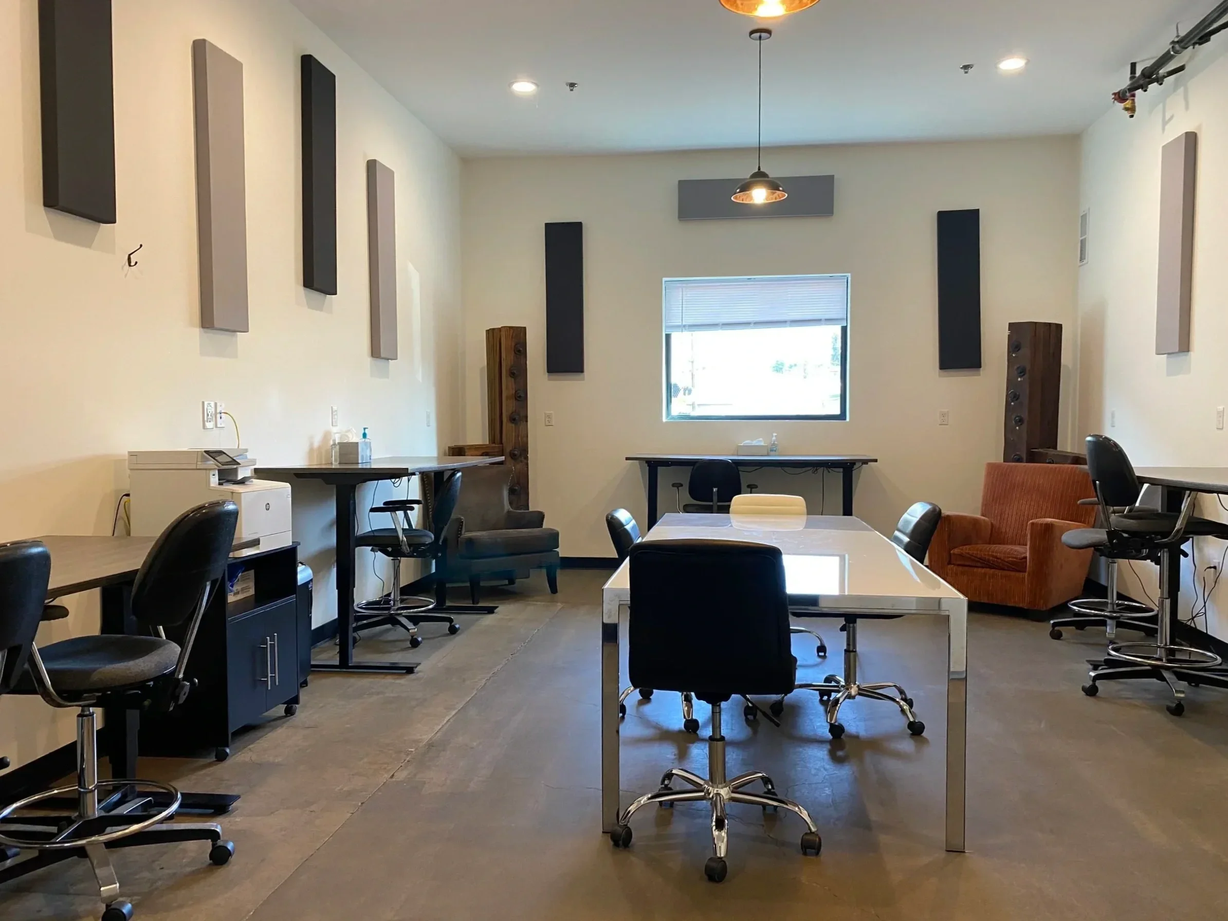 A spacious production office with a large table and multiple workstations.