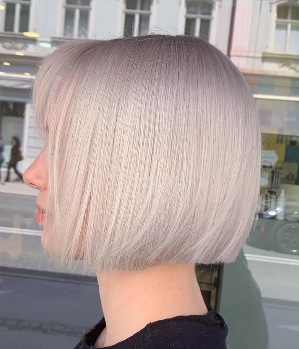 Nahaufnahme eines Haarschnitts mit glattem, chinlangem Bob, silbrig-blondene Haarfarbe, vor einem Schaufenster