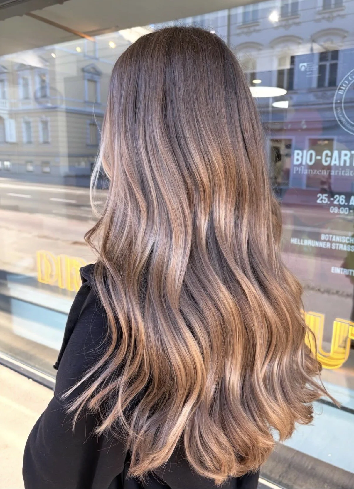 Braune Balayage mit warmen Karamell-Reflexen in langem, gewelltem Haar – all about hair esra Salzburg