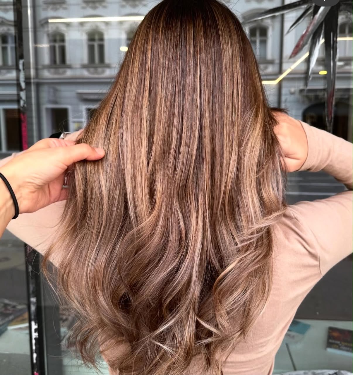 Frau mit langem, welligem, shimmery Haar in Hellbraun mit Highlights