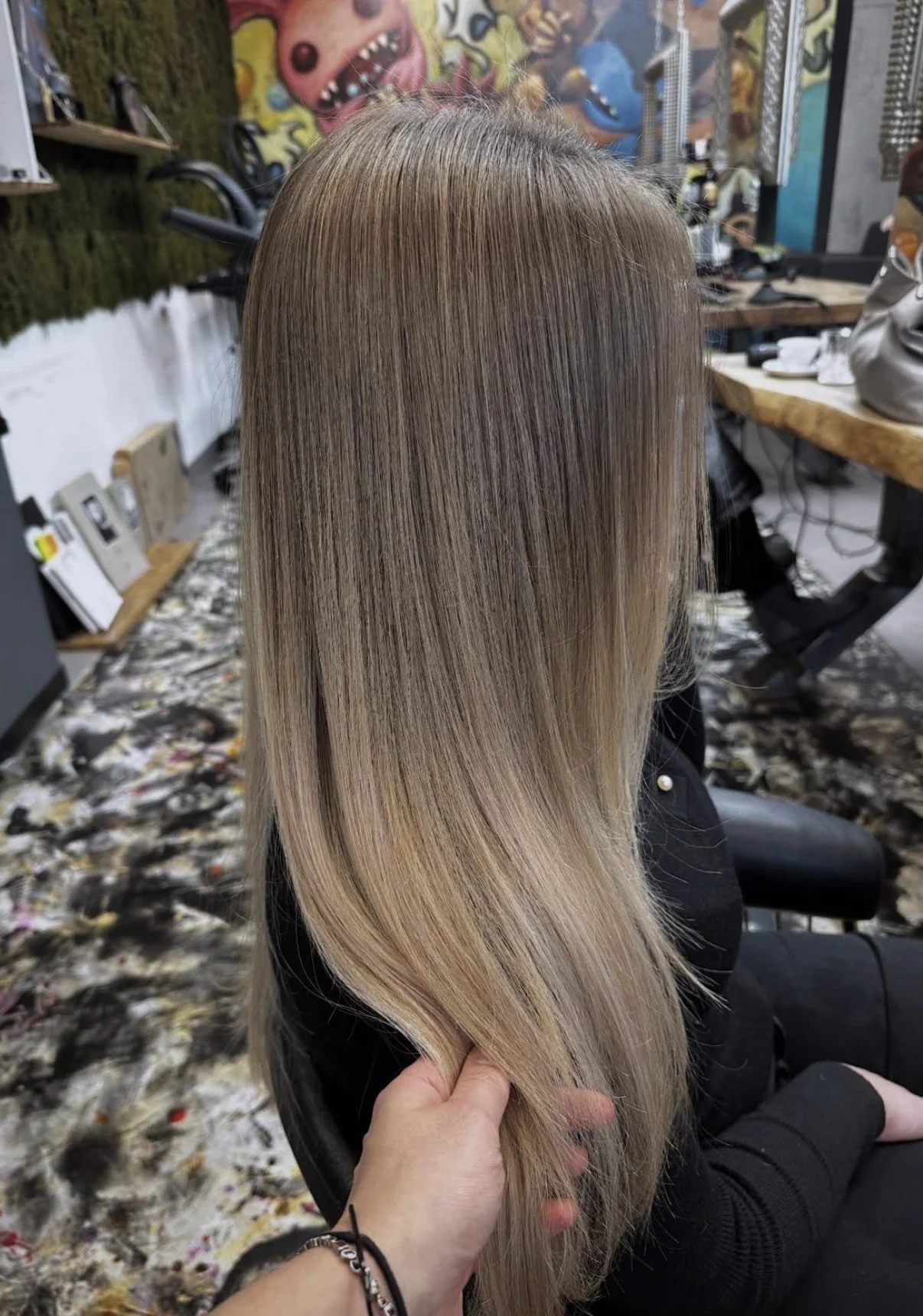Glänzende blonde Balayage an langem, glattem Haar im Friseursalon Salzburg