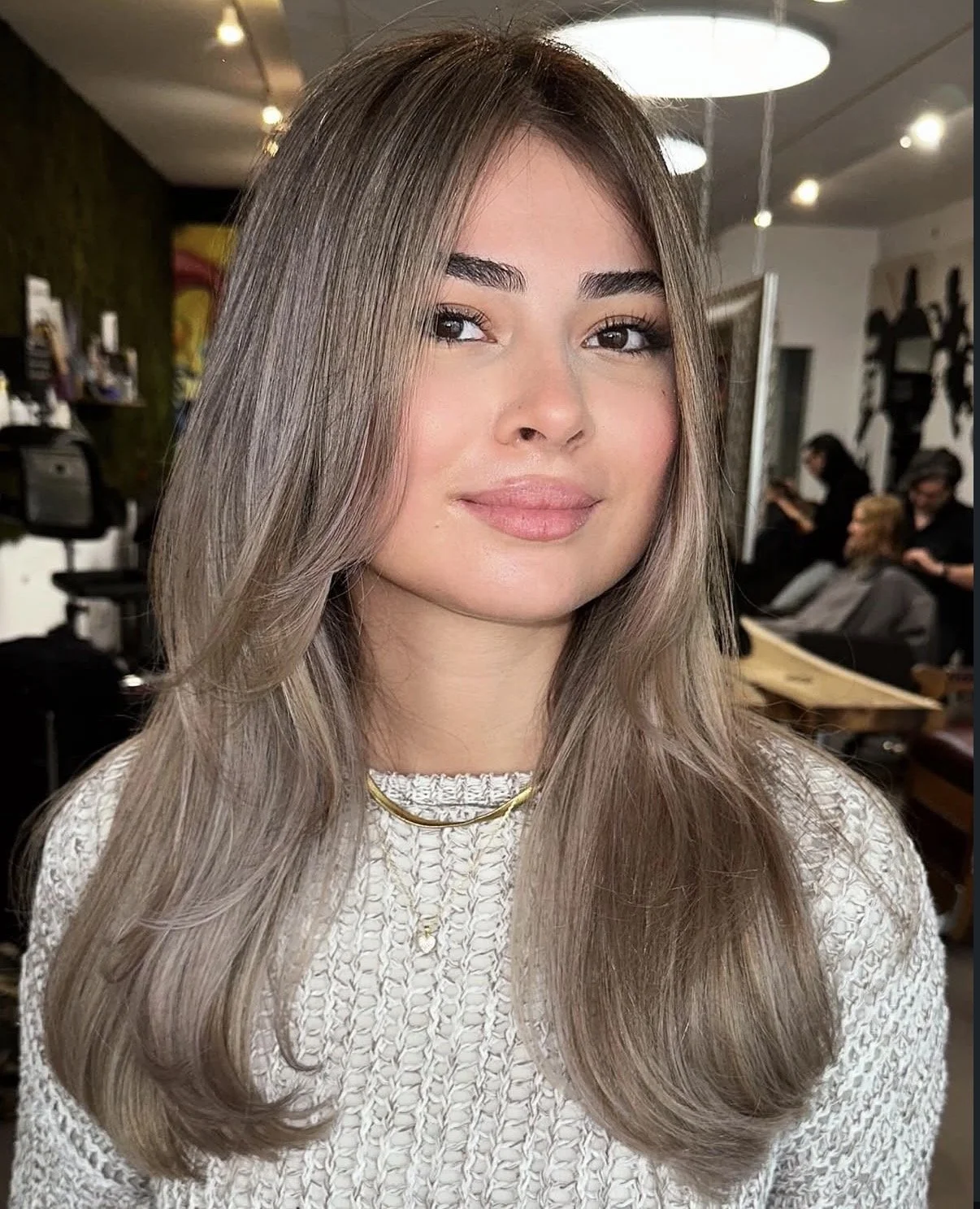 Kundin mit langen, braunen gewellten Haaren nach dem Styling bei all about hair esra