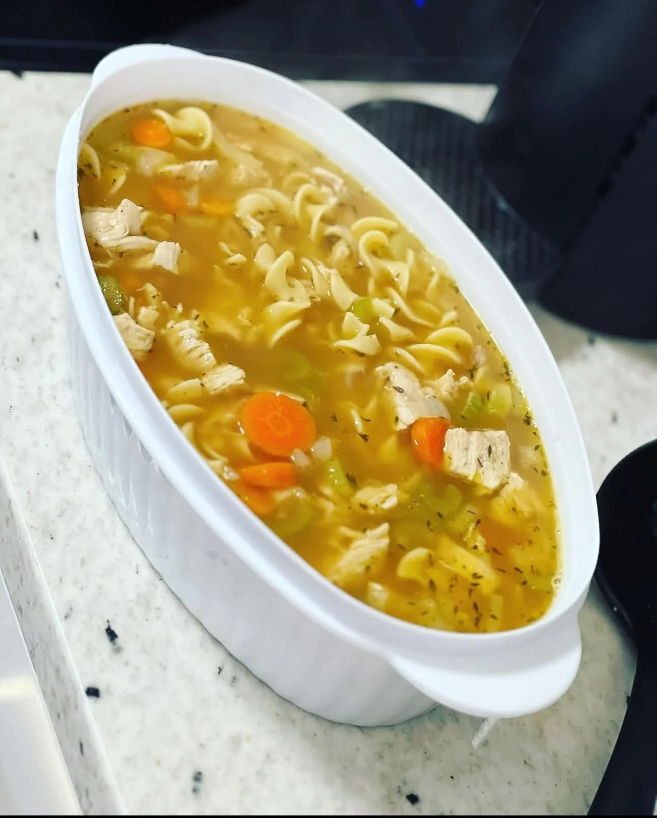 Warm homemade chicken noodle soup with vegetables, highlighting postpartum doula meal‑prep services for new moms in Greenville SC.