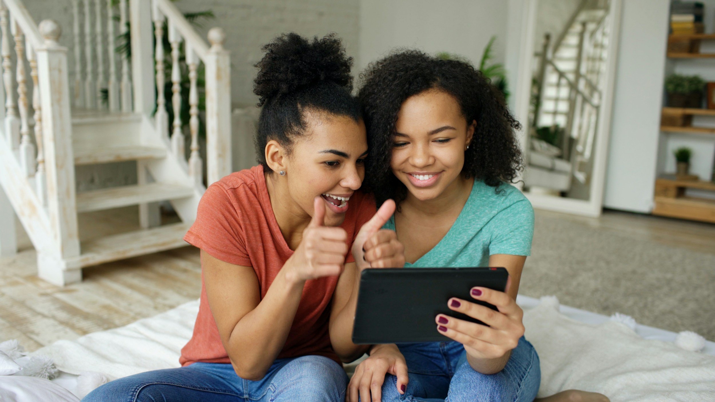 Two young women in Greenville SC looking at a smartphone and smiling as they explore postpartum doula services.