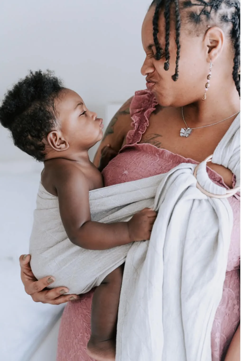 Postpartum doula in Greenville SC showing how to use a baby wrap with her own baby during an baby-wearing  in‑person support session.