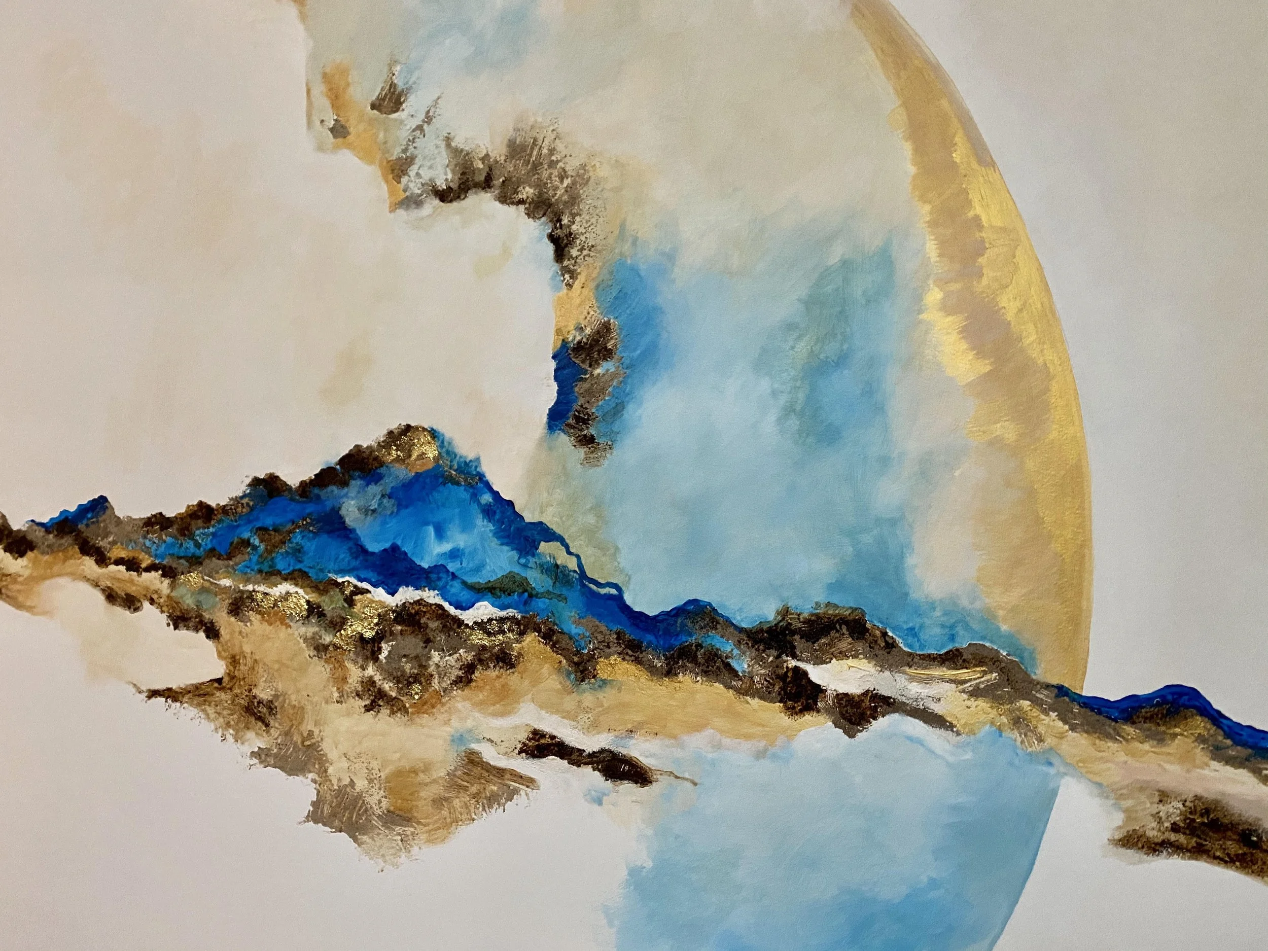 Peinture abstraite représentant une montagne avec des couleurs bleues, marron, or, blanc et beige.