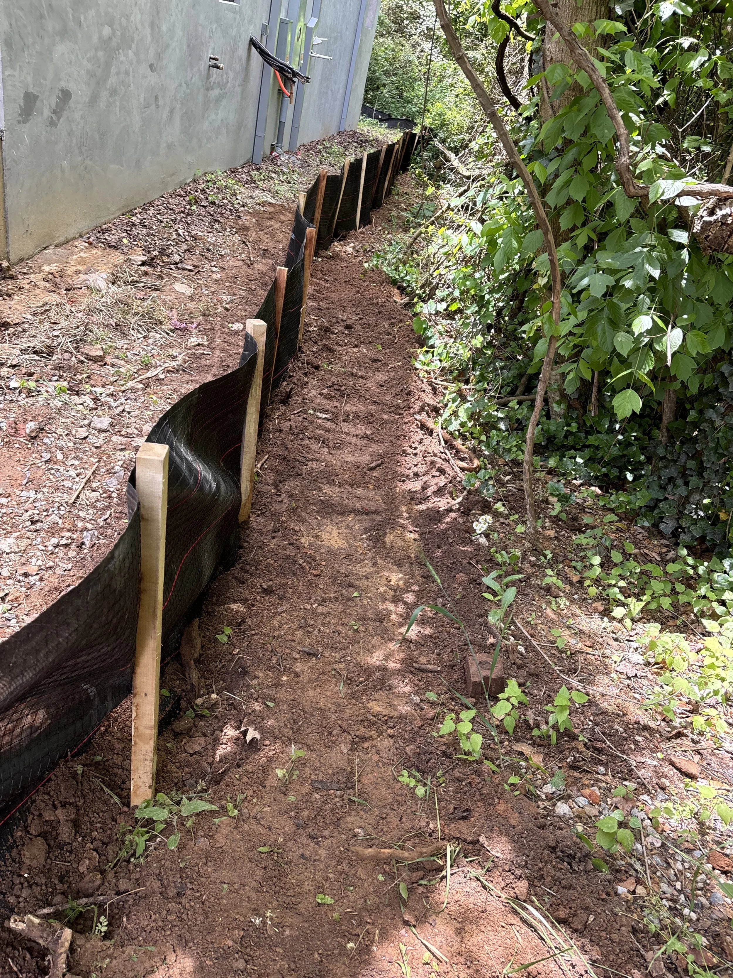 Commercial silt fence installation and perimeter erosion control along a wooded lot line by Taproot Contracting in Northeast Georgia.