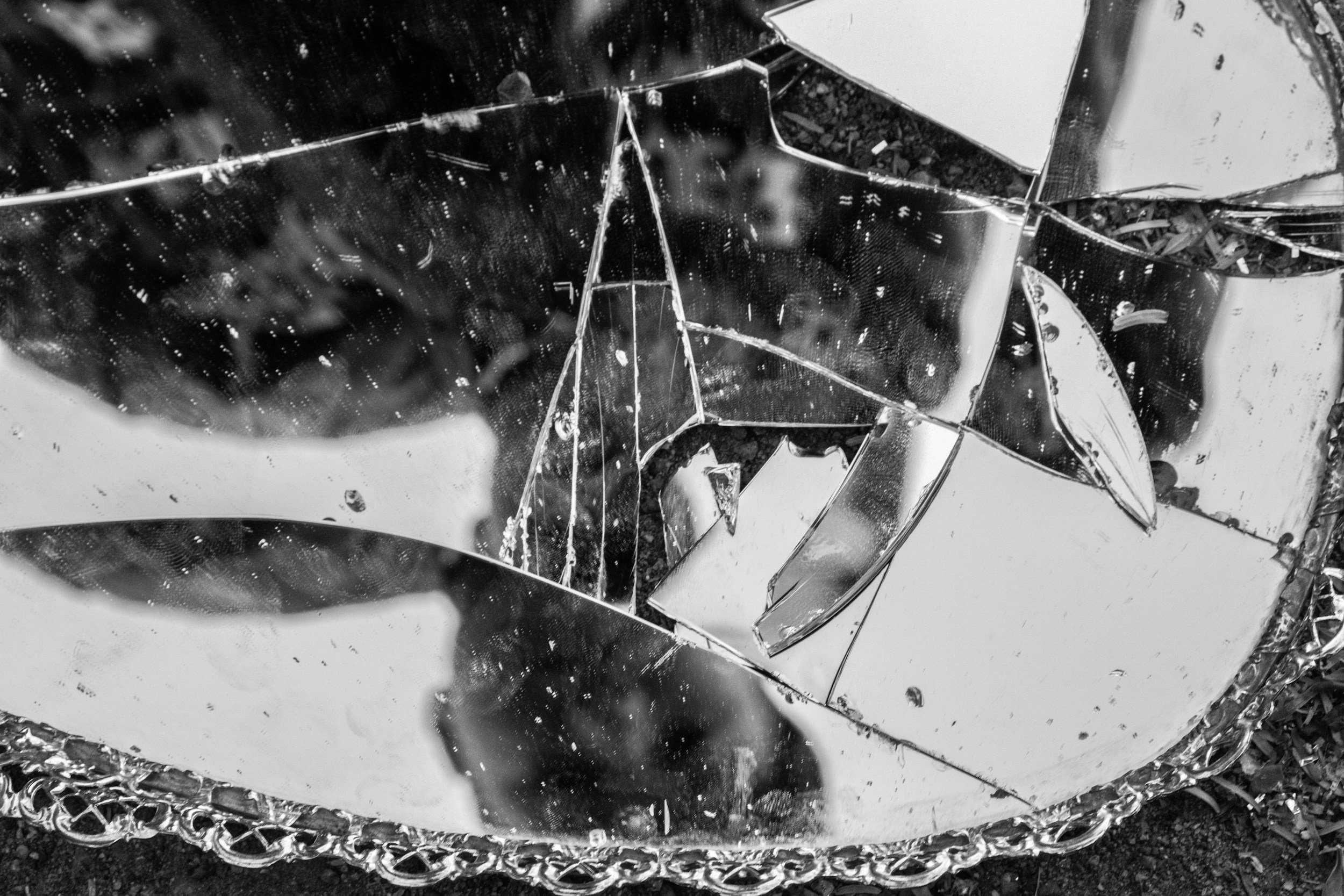 Close-up of shattered and broken glass with reflective surfaces.