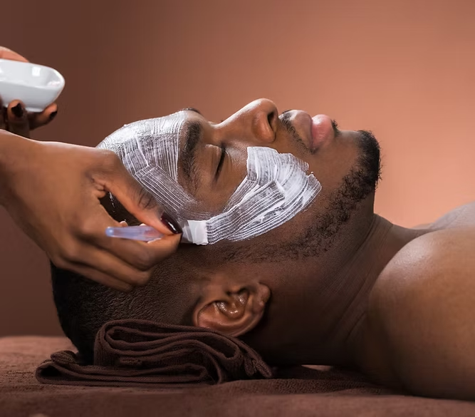 A man receiving a facial treatment with bands around his face while lying down.