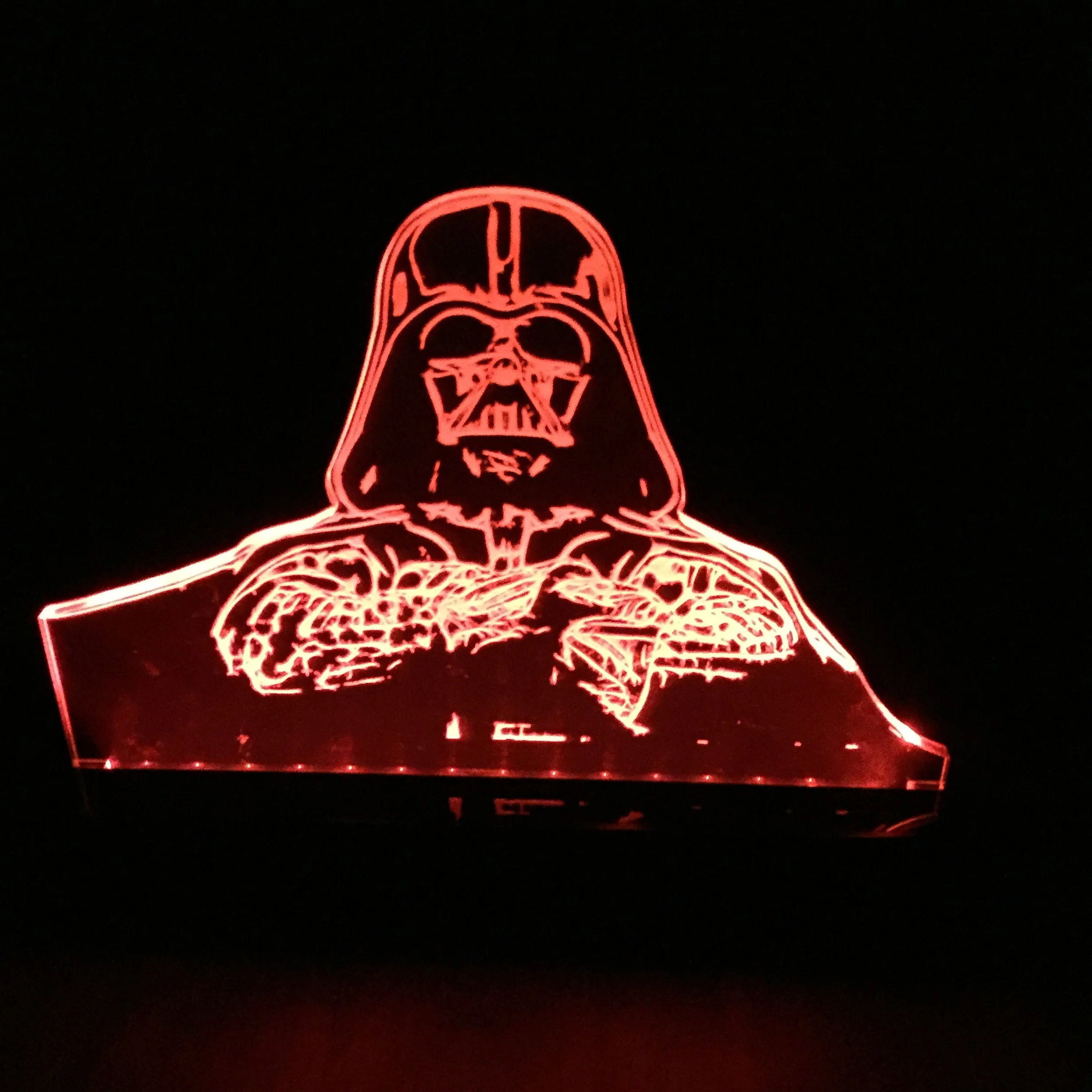 Neon outline of Darth Vader's helmet illuminated in red on a dark background.