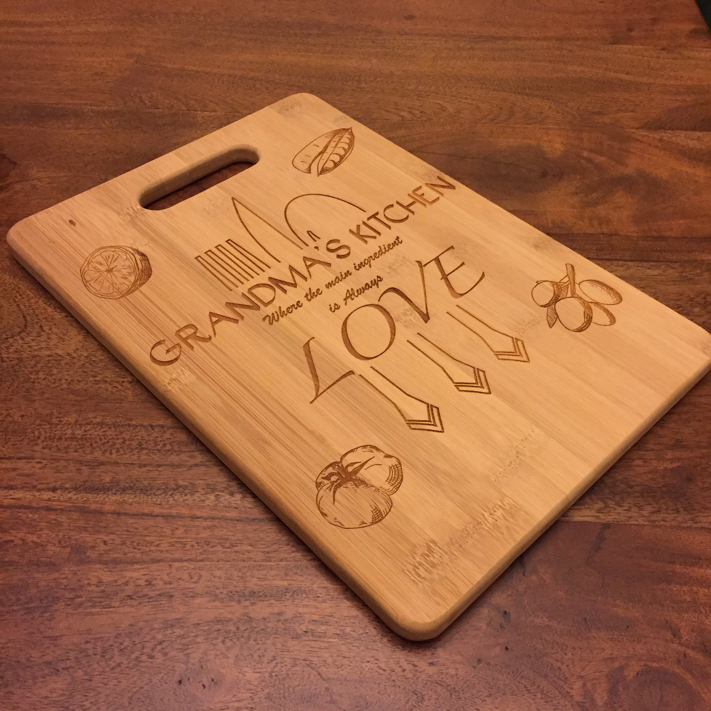A wooden cutting board with engraved drawings of a lemon slice, a leaf, and a cinnamon stick, placed on a wooden surface.