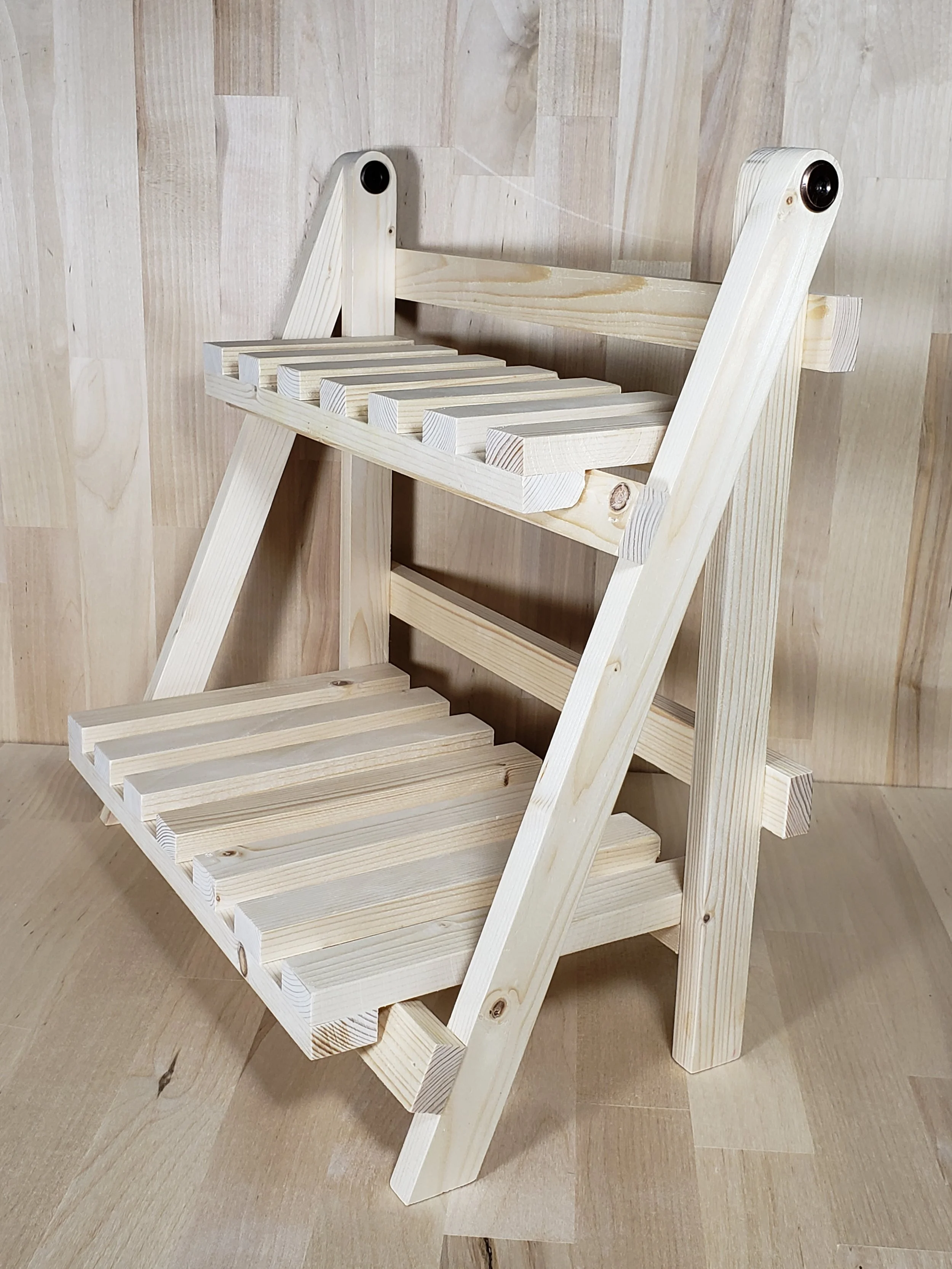 A small wooden chair with slatted seat and backrest, made of light-colored wood, placed on a wooden floor.