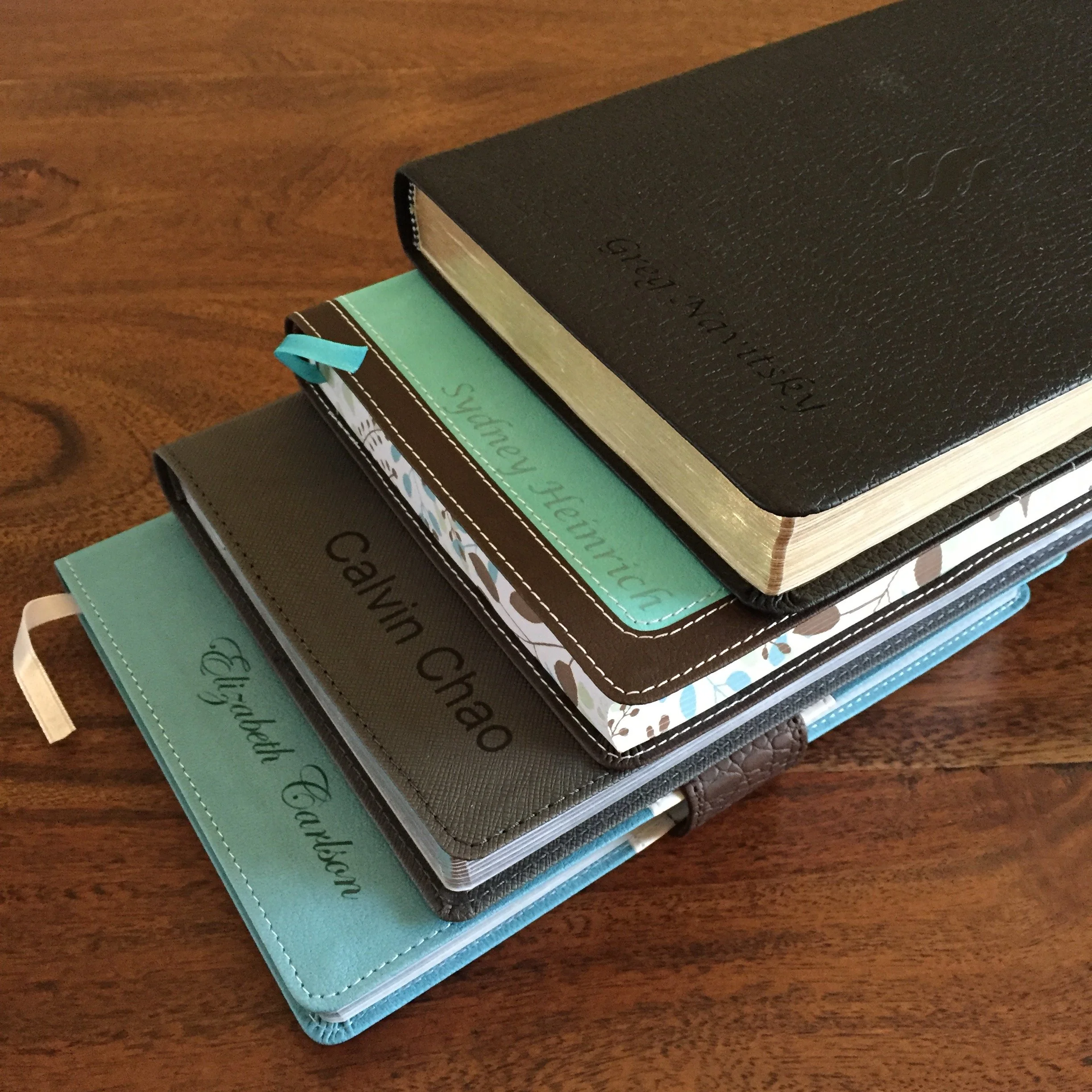Stack of several books with different colored covers on a wooden table.