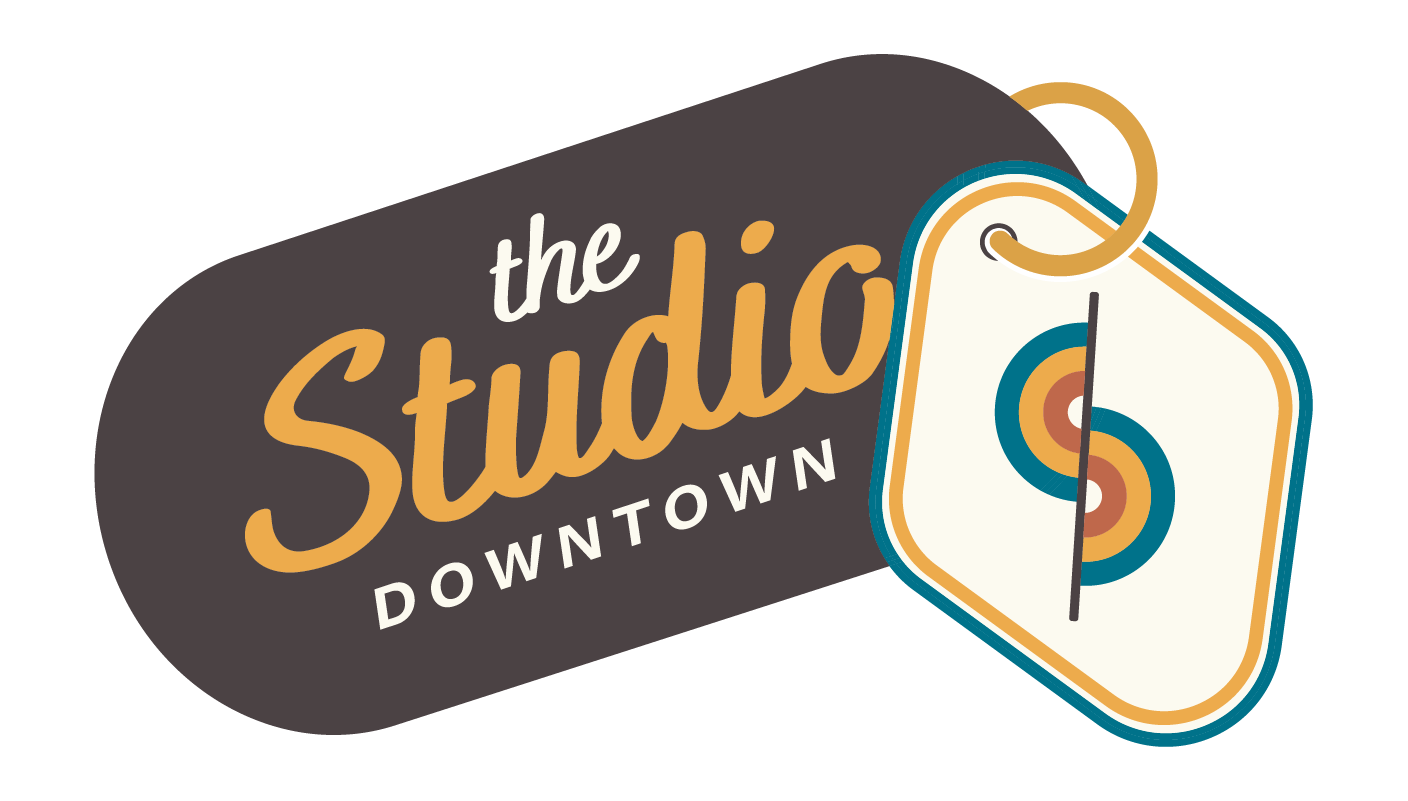 Logo for The Studio Downtown featuring stylized text and a pair of colorful location tags.
