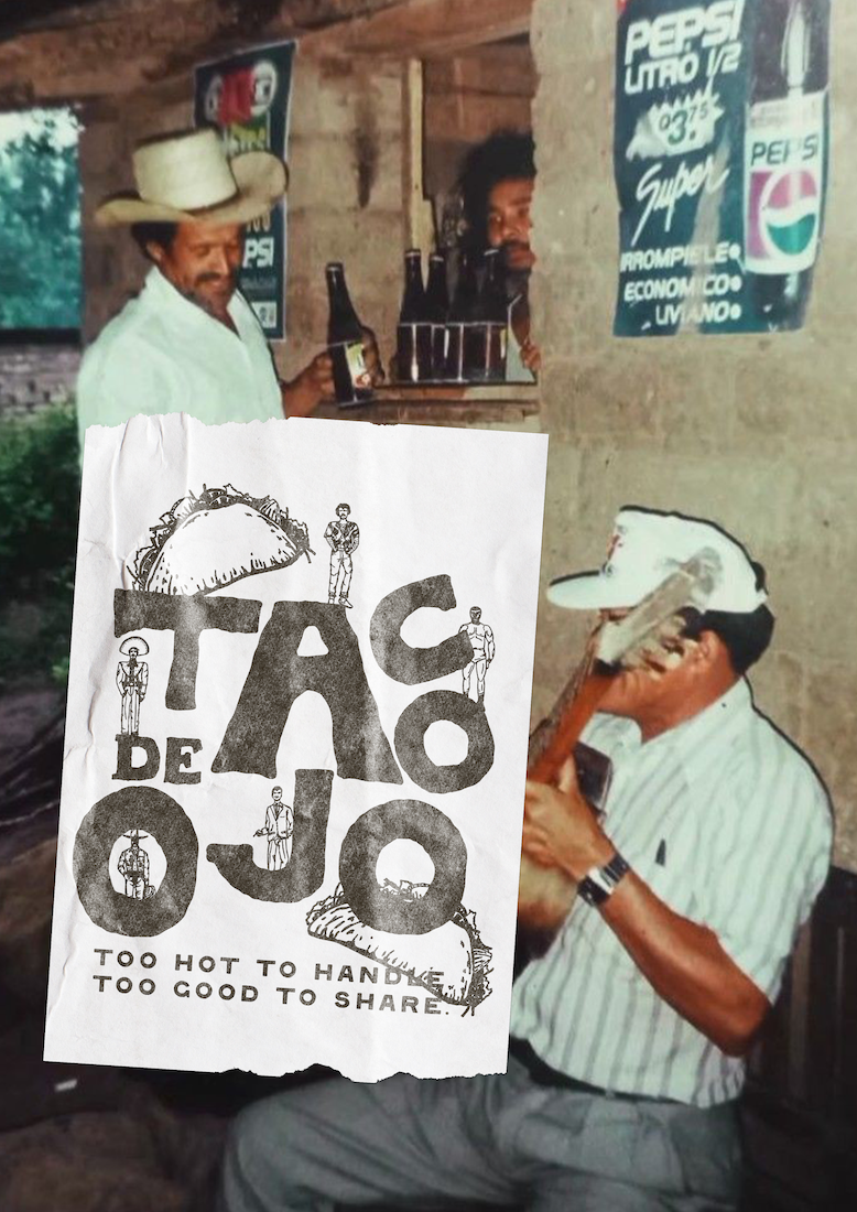 Two men in a rustic setting with posters on the wall. One man is sitting, wearing a cowboy hat and holding a bottle, while the other is standing and has curly hair with a beard. A crumpled paper with the text 'Taco De Joco' and the phrases 'Too hot to handle, too good to share' is being held in front of the camera.