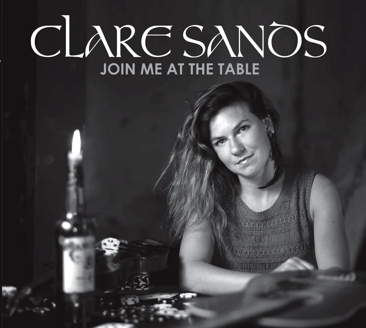 Black and white album cover featuring a woman with wavy hair, sitting at a table with poker chips and a lit candle, with text that reads "Clare Sanso, Join Me At The Table."