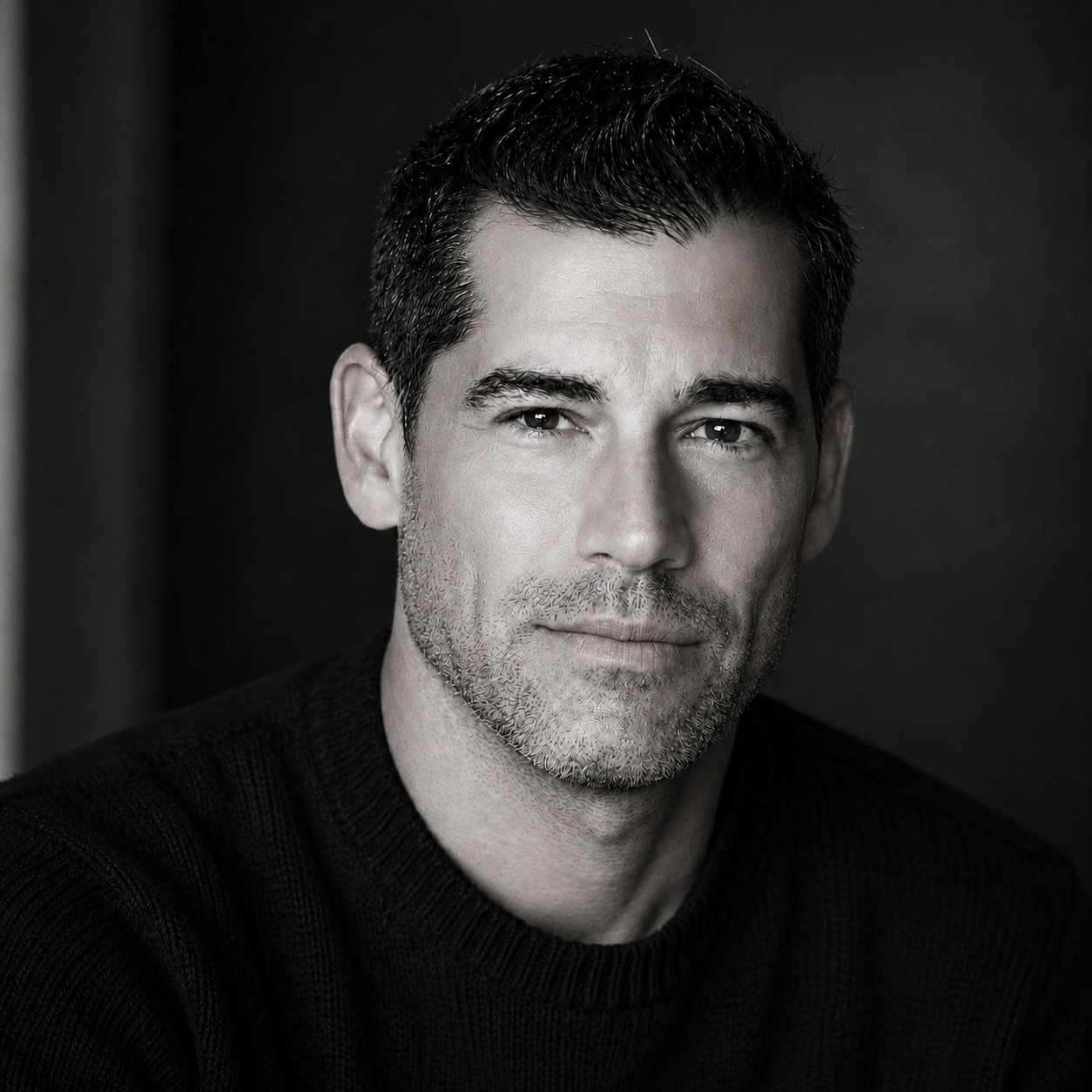 Professional headshot of Brett Wickman, black and white.