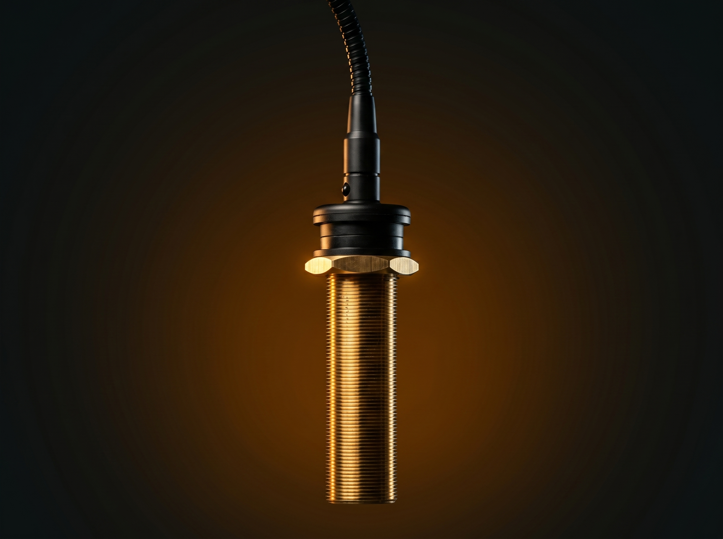 A close-up shot of a microphone with a black and gold design, set against a dark background with warm lighting