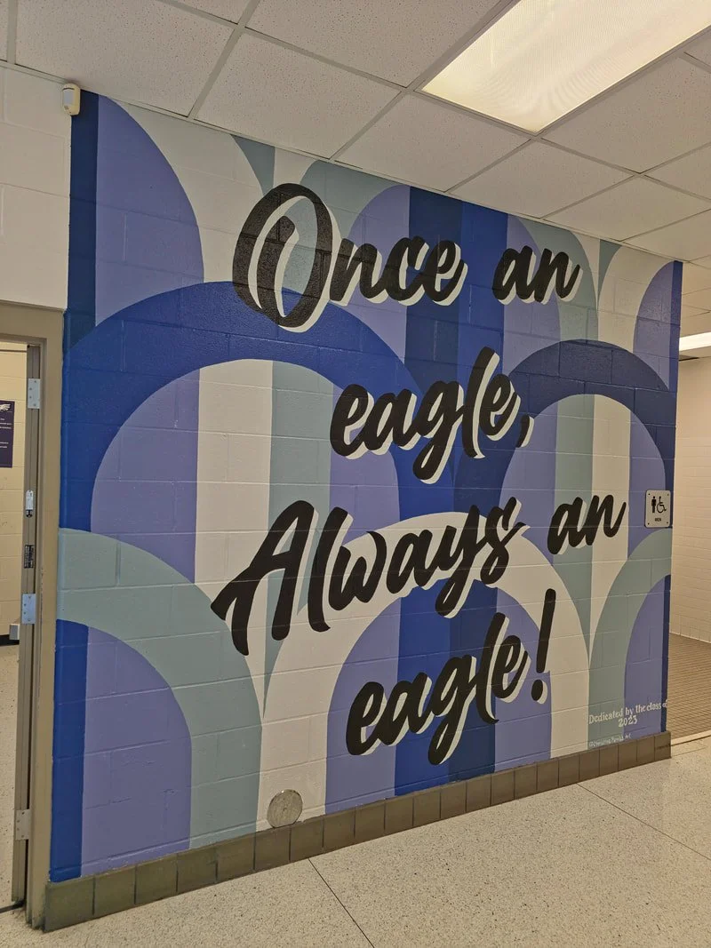 School hallway wall with a colorful mural featuring an eagle and the quote 'Once an eagle, Always an eagle!'