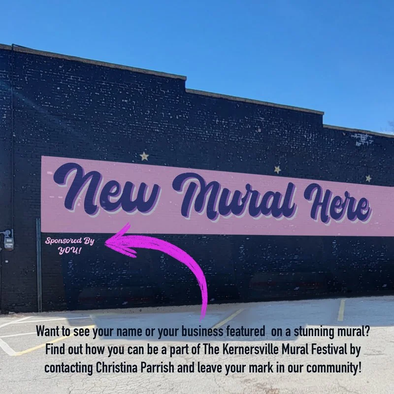 A mural in progress with the text 'New Mural Here' and an arrow pointing to the left. The mural is on a dark wall, with a parking lot below and a clear blue sky above. The mural promotes community involvement in the Kernersville Mural Festival.