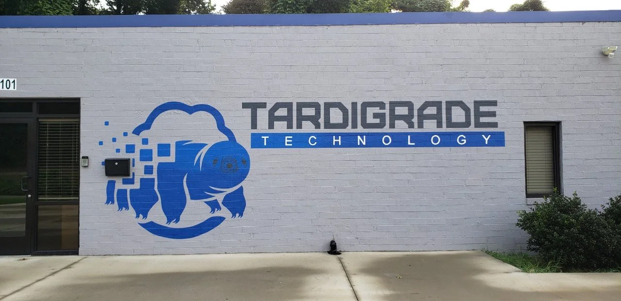 Blue graphic of a pig with pixelated effects next to the text 'Tardigrade Technology' on a white brick wall.