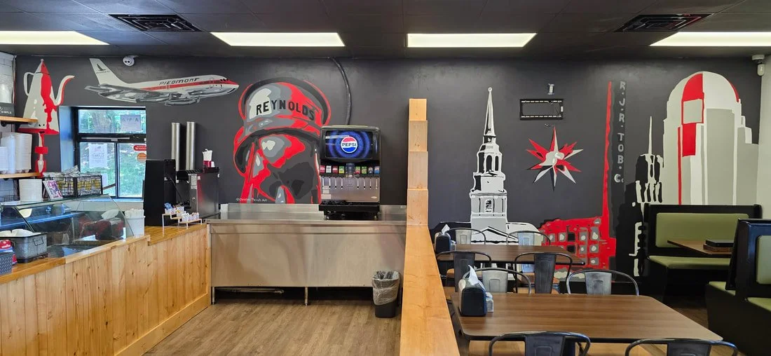Interior of a cafe with graffiti-style cityscape murals, a soda fountain machine, and wooden furnishings.