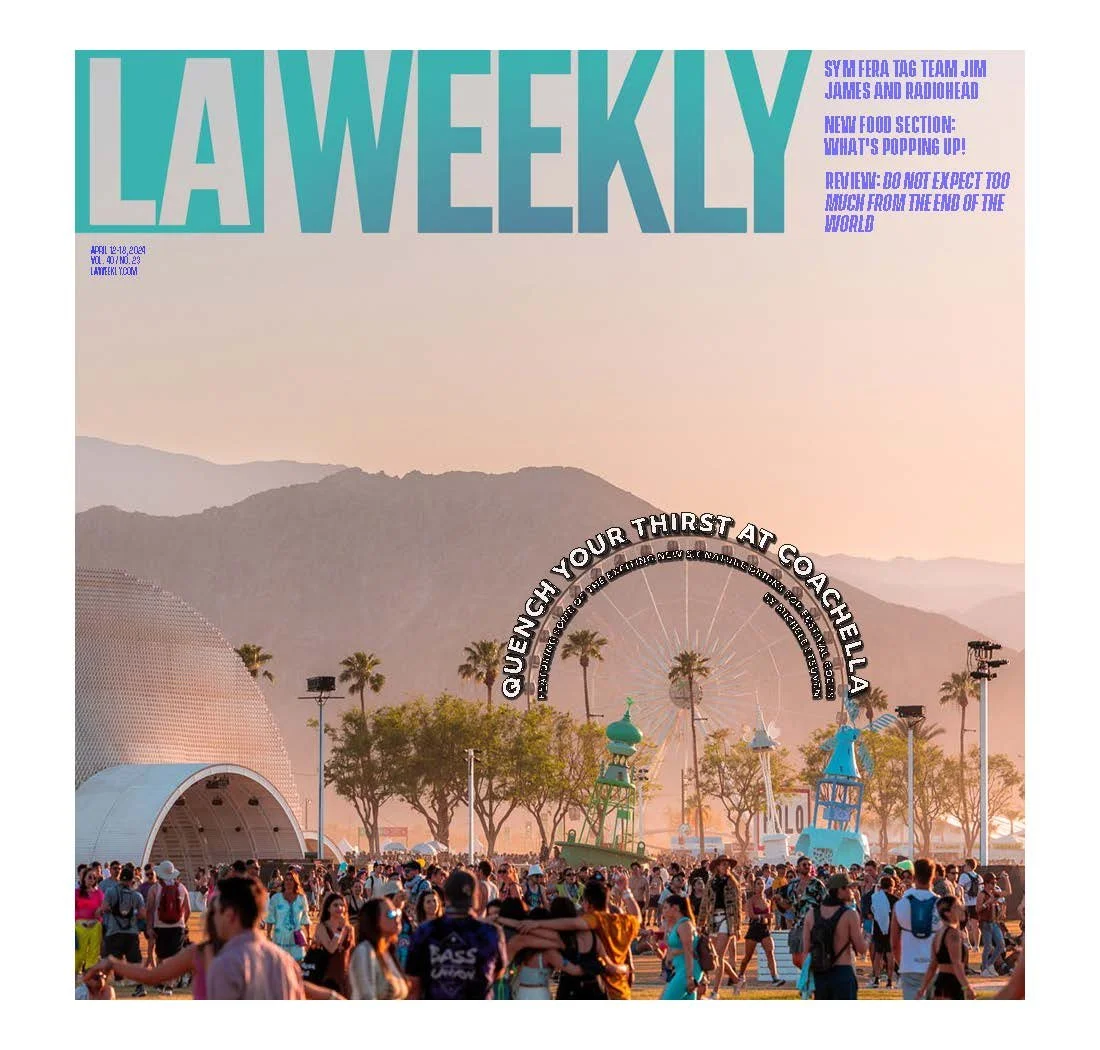 Cover of LA Weekly magazine featuring a busy outdoor event at dusk with colorful amusement rides, a Ferris wheel, and palm trees against a mountainous background.