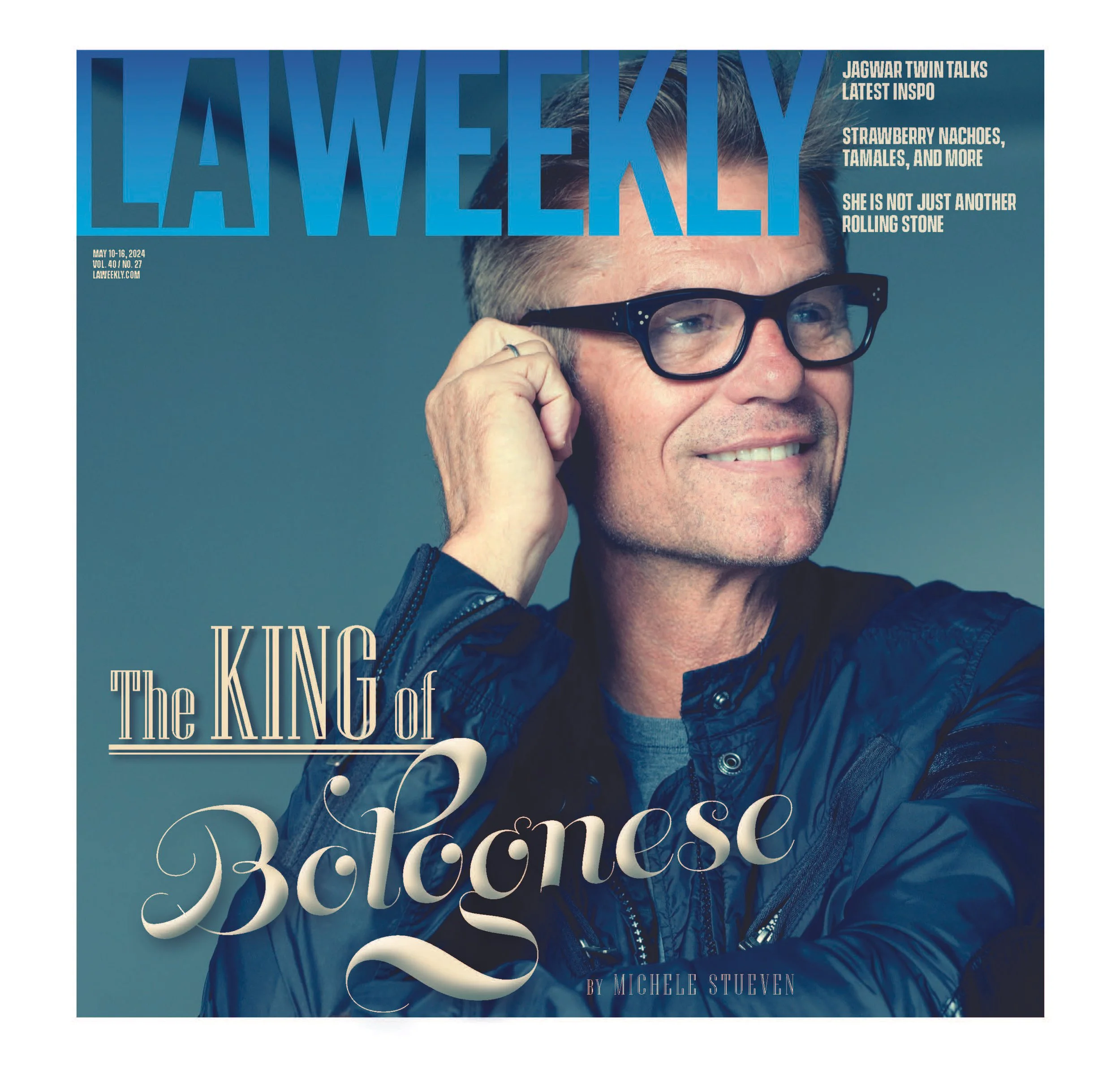 Magazine cover of LA Weekly featuring a smiling middle-aged man with glasses, wearing a dark jacket, touching his ear, with the headline 'The King of Bologna' by Michele Stueven.