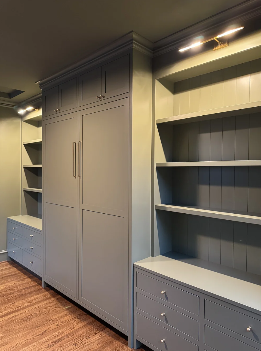 Built-in cabinetry with Murphy bed, shelves and drawers in a room with hardwood flooring.