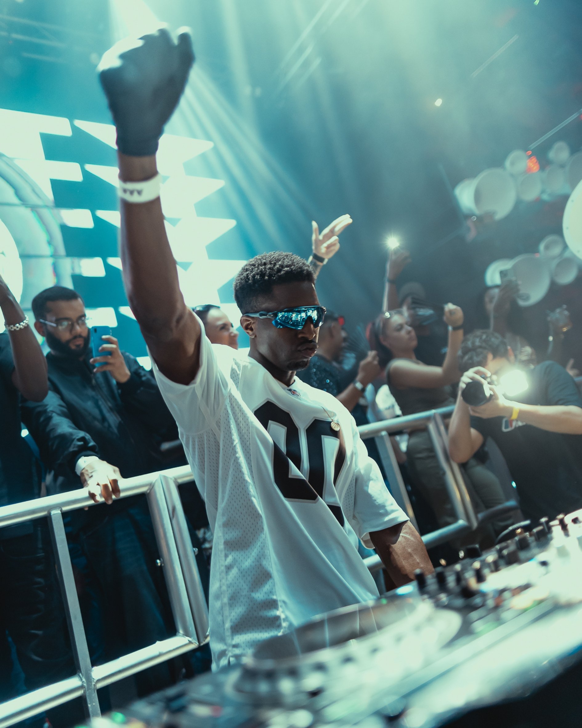 Hitty playing at 338,  colorful lights and a DJ in the foreground wearing sunglasses.