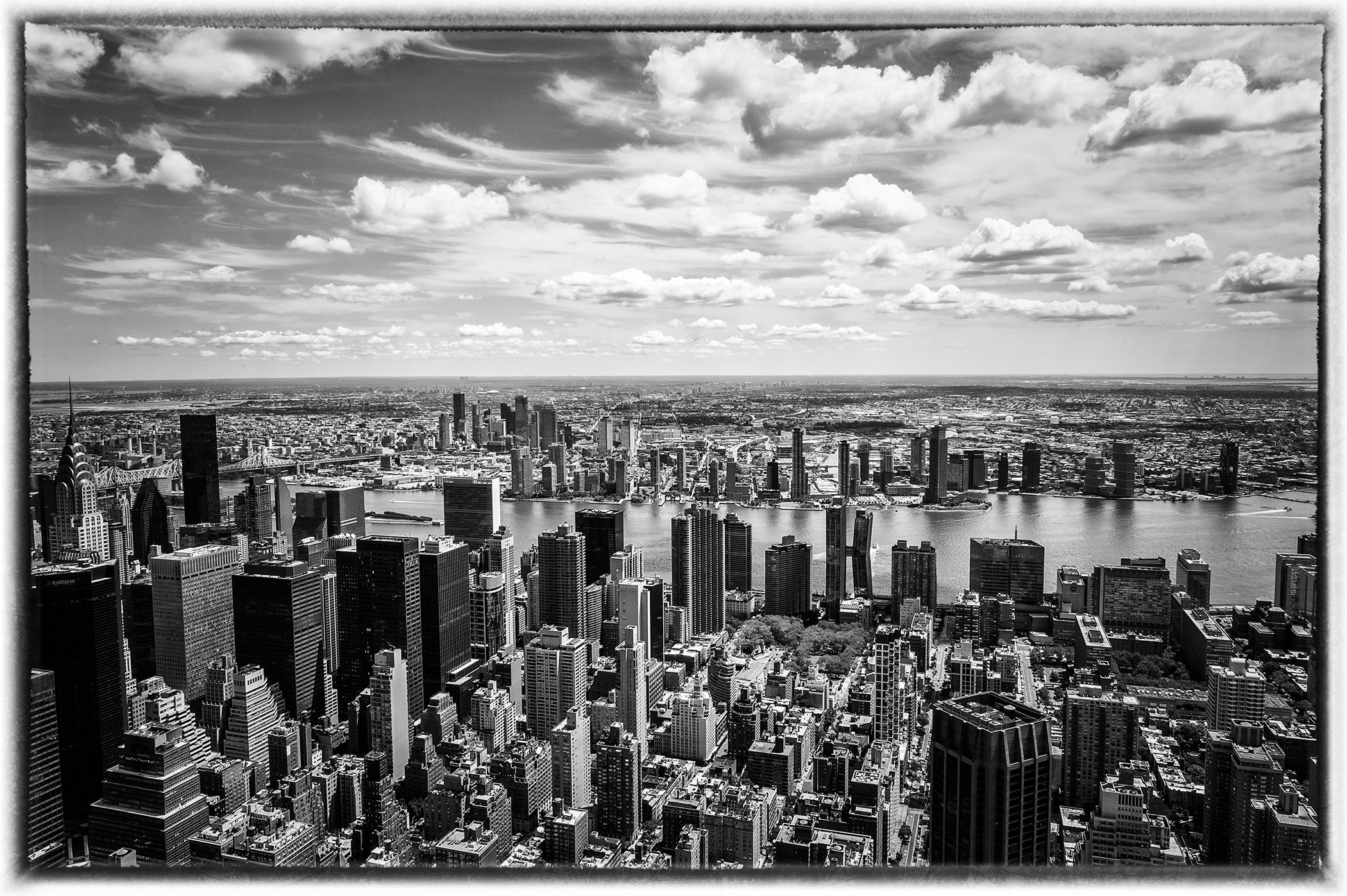 Capture the magic of New York City with this stunning black and white view from the iconic Empire State Building. There's a timeless quality to black and white photography that brings out the soul of the city — the towering skyline, the endless energ
