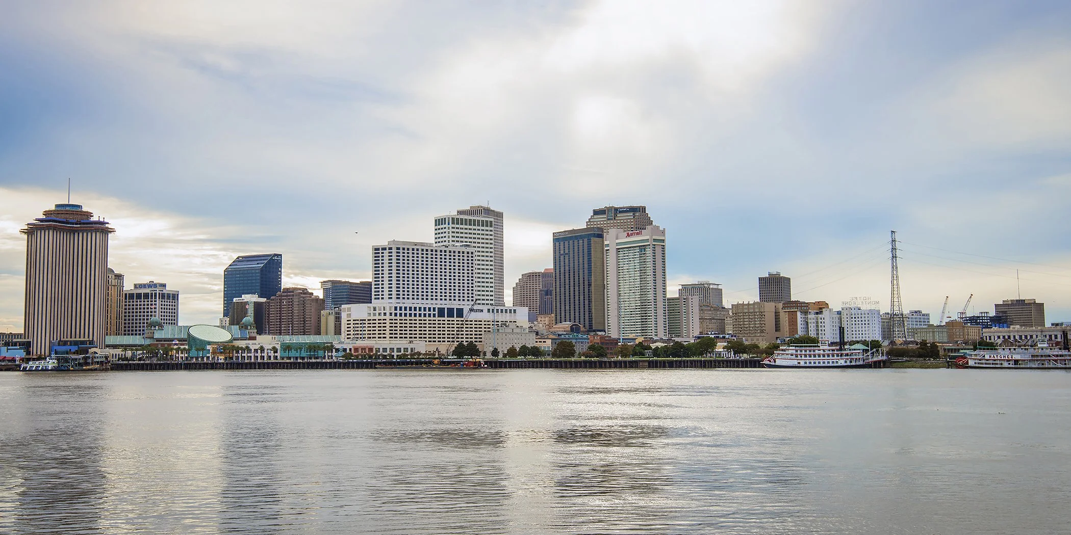 This stunning waterfront view captures downtown New Orleans as seen from the Westbank — a peaceful, panoramic look at the Crescent City’s iconic skyline. From the curve of the Mississippi River to the high-rises and steamboats, this print brings a qu