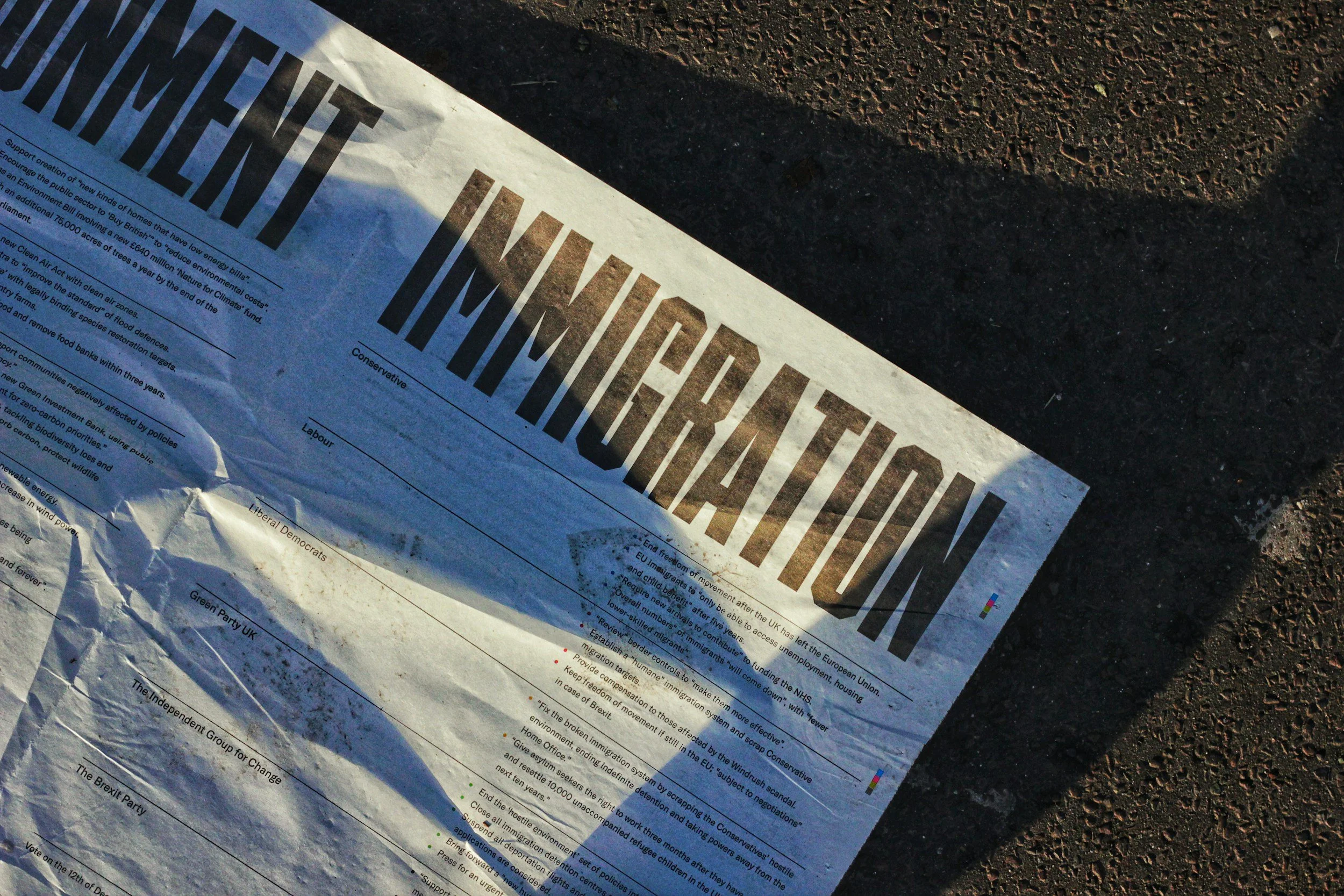 A printed newspaper titled 'BREXIT' lying on rough ground. The paper appears wrinkled and partially crumpled, with some text visible beneath the title.
