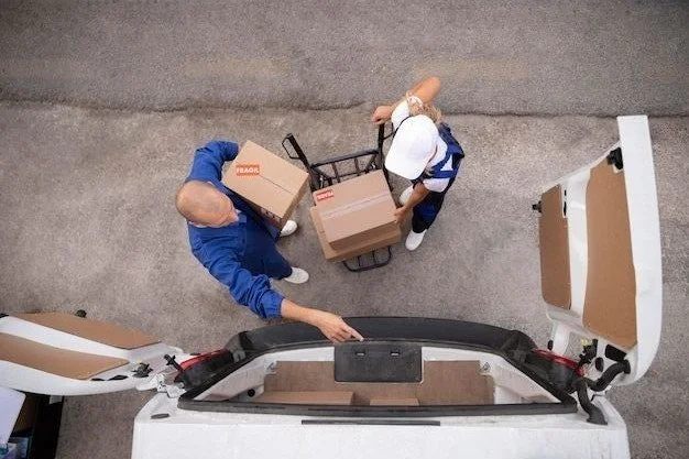 Dos personas descargando cajas de una camioneta al lado de un carrito de mano.