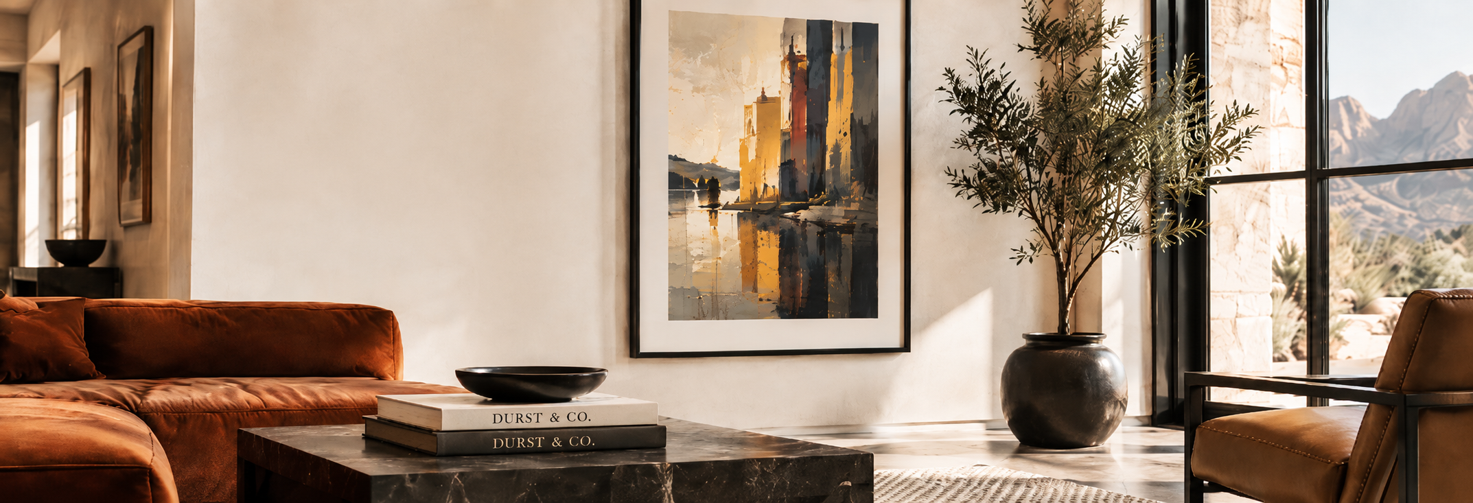 Modern living room featuring a rust-colored sofa, a concrete coffee table with books, a large abstract painting of a cityscape, a potted plant near a glass door, and mountain scenery outside.