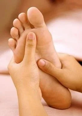 Close-up of a person receiving a foot massage or reflexology session.