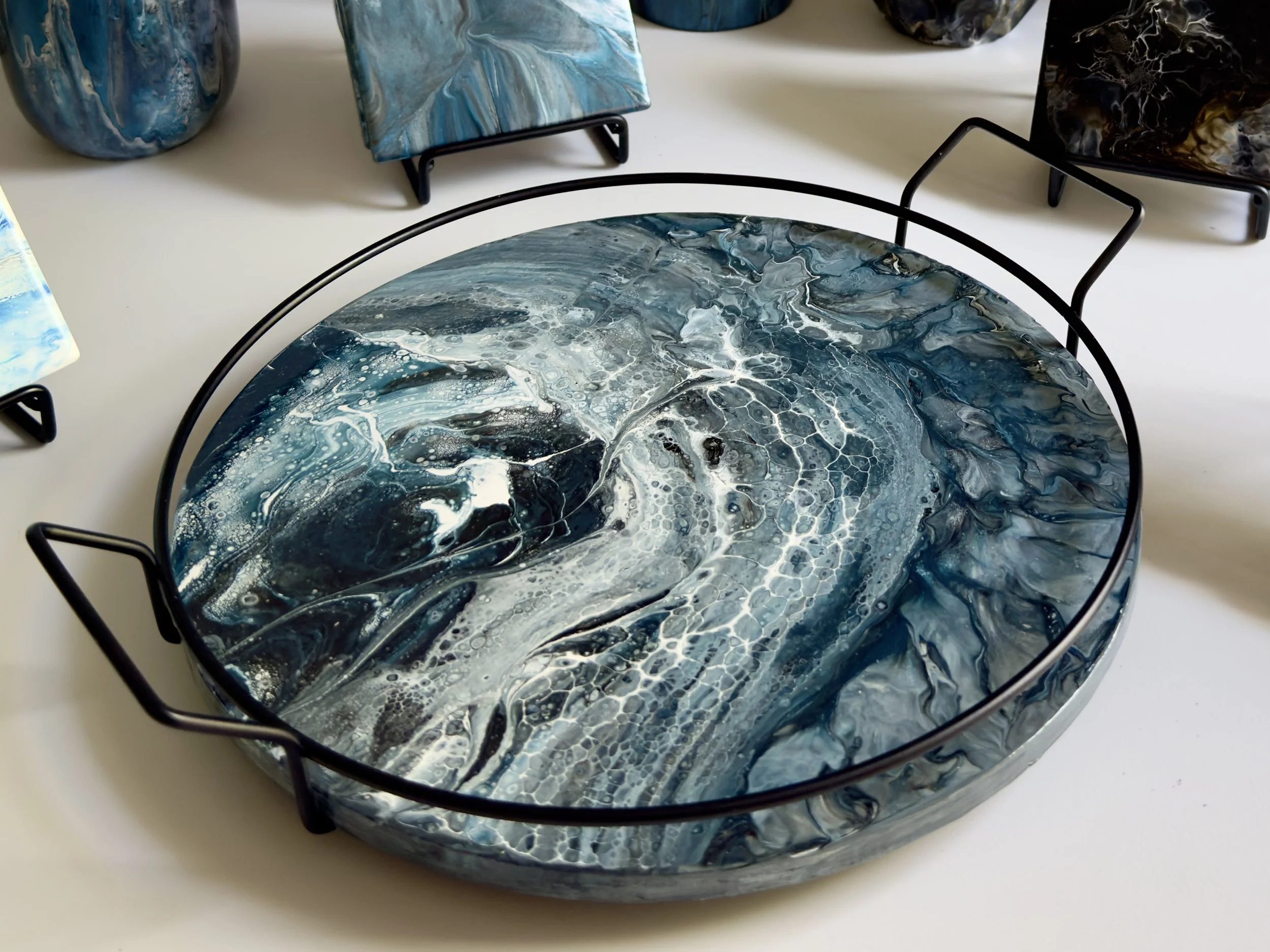 Round functional lazy susan featuring layered blue, gray, and white acrylic pours that evoke shifting water, depth, and quiet movement.