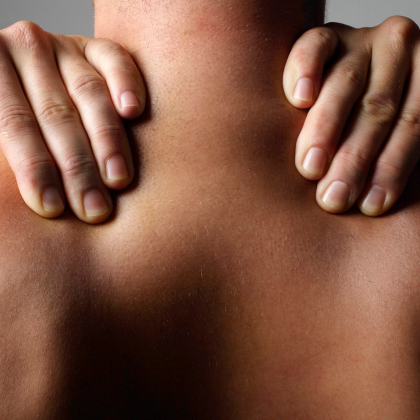 Close-up of a person's back with hands resting on shoulders.