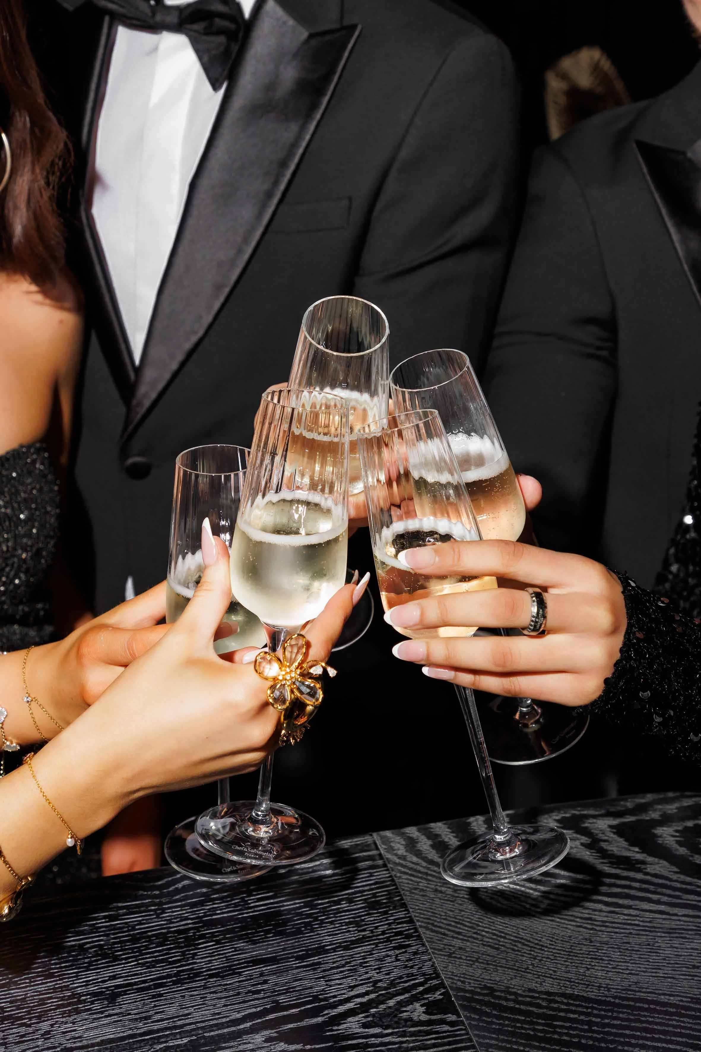 People in formal attire clinking champagne glasses in a celebration.