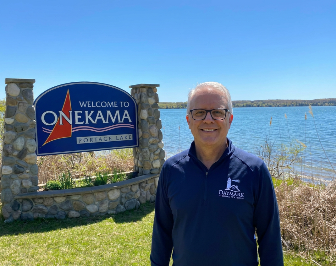 Jim Casler of Daymark Home Watch out on the water near Onekama, Michigan welcome sign.