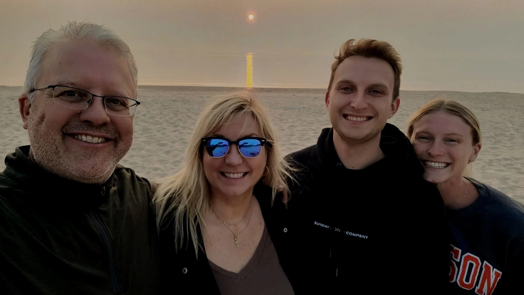 Jim Casler and family on the Portage Point Beach in Onekama, Michigan. Daymark Home Watch