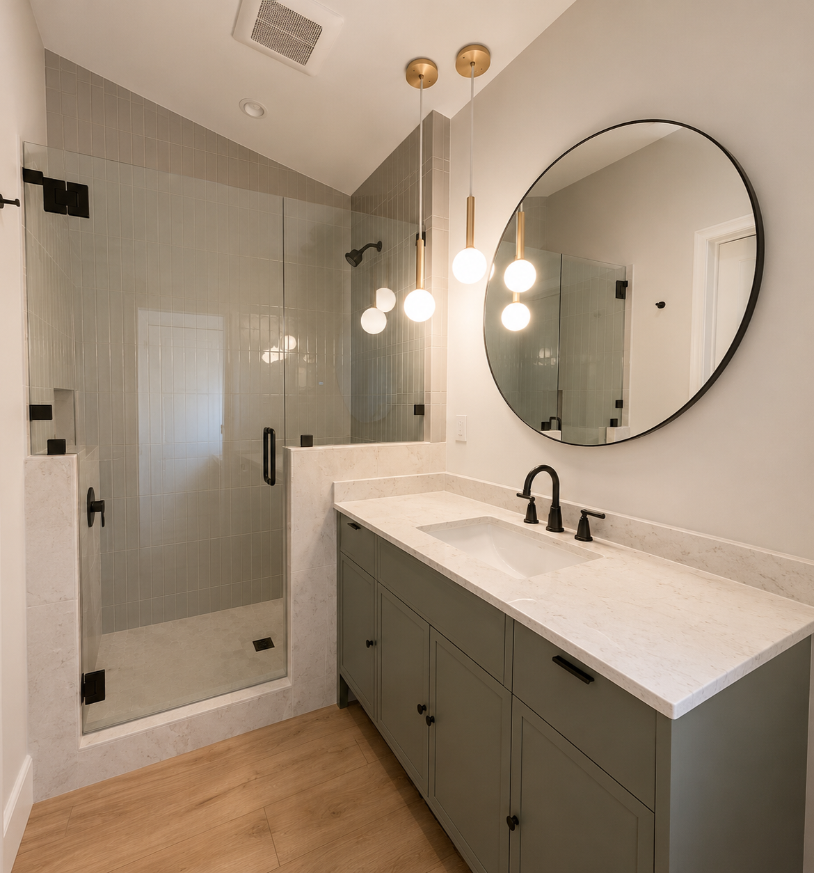 Modern bathroom with a walk-in shower and a white marble vanity with a round mirror and hanging light fixtures.