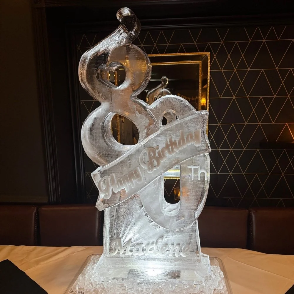 Ice sculpture that reads 'Happy Birthday' and the name 'Madeline' engraved.