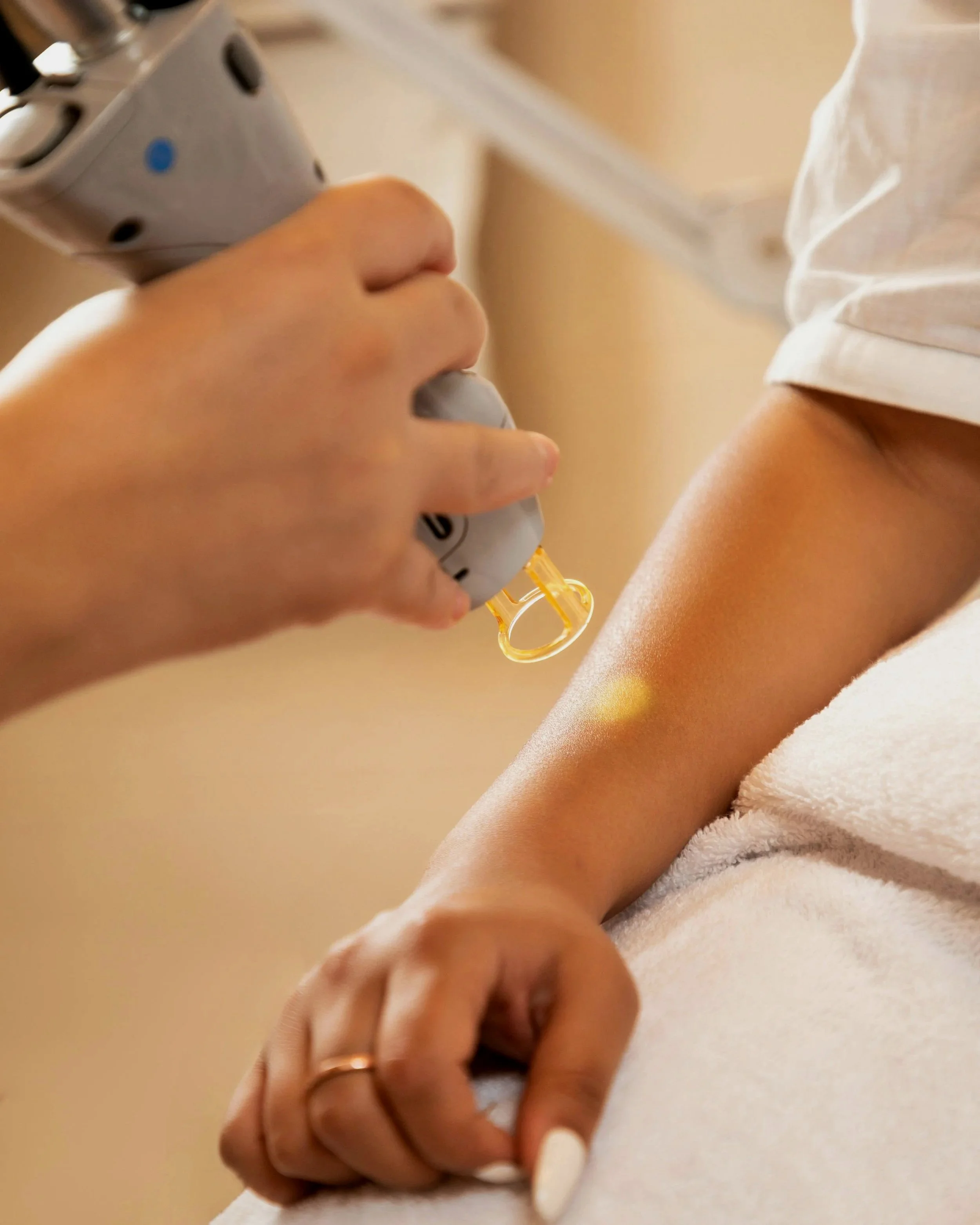 A person holding an insulin pen with a yellow cap, preparing to administer an injection in their arm.