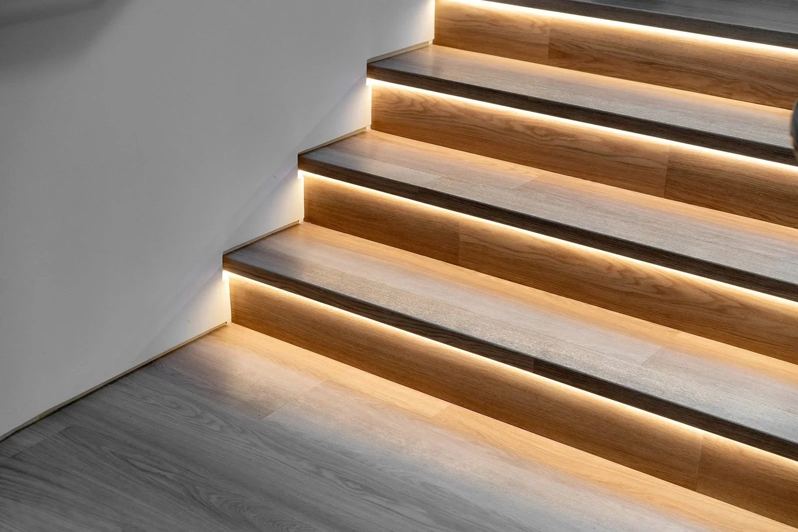 Modern wood staircase with integrated lighting representing taking the next step with Interior Law LLP..