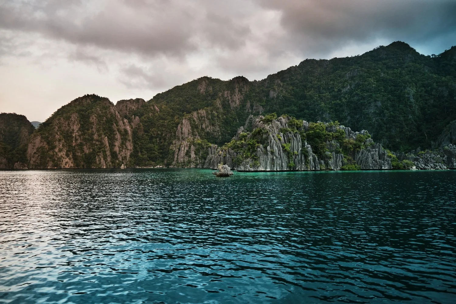 Limestone cliffs above turquoise water in Palawan, Philippines