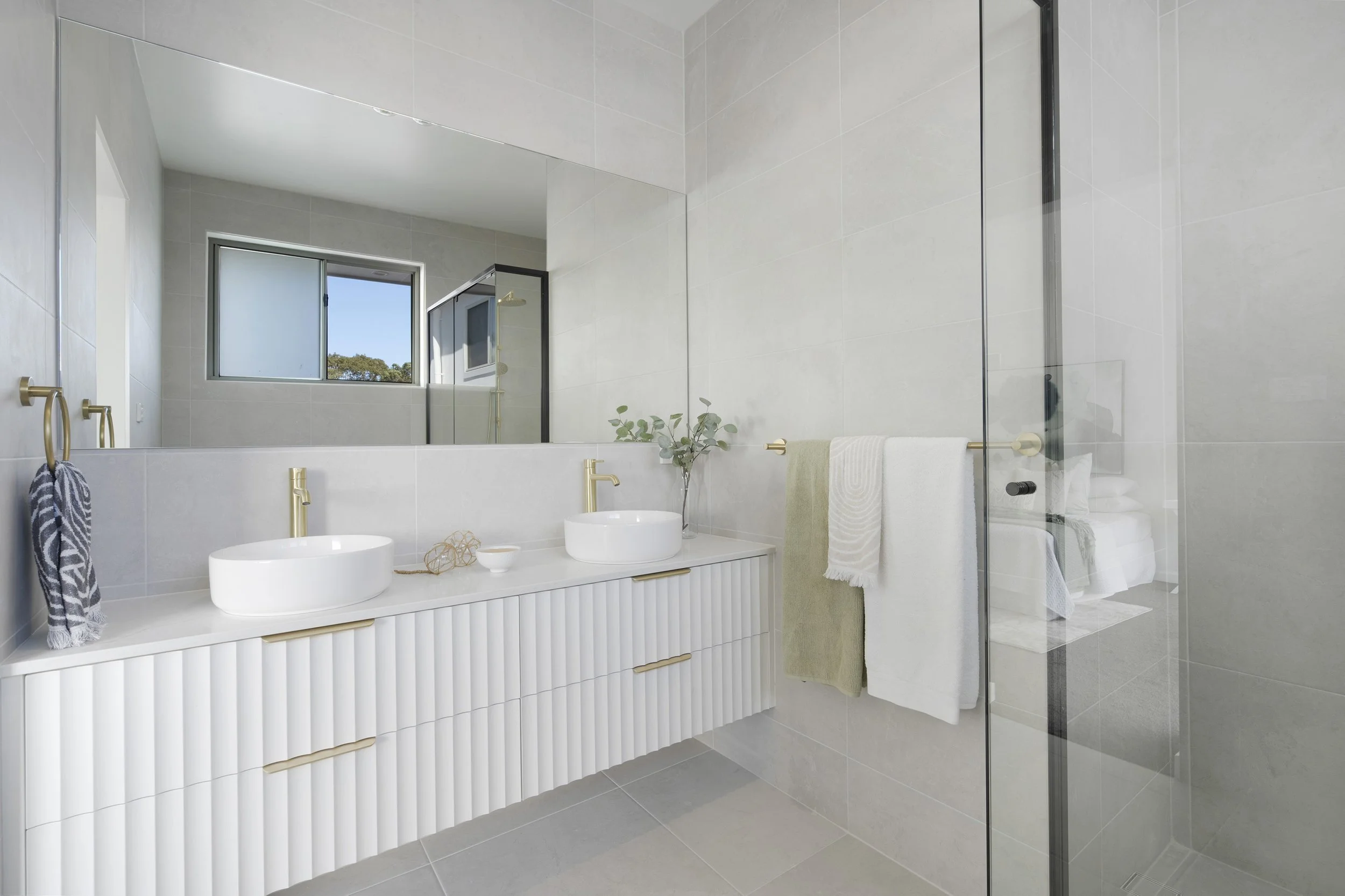 Modern bathroom with white tiled walls and floor in Newcastle custom built by SWW BUILDING GROUP