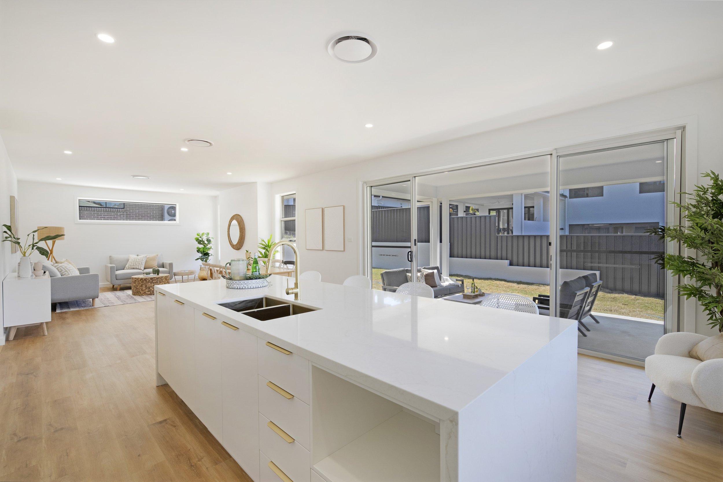 An open-concept living and dining area with large sliding glass doors leading to an outdoor patio in Maitland custom built by SWW BUILDING GROUP
